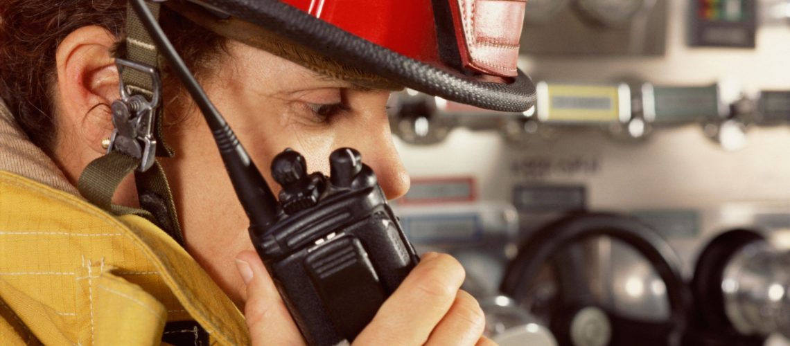 Firefighter in uniform using a two way radio